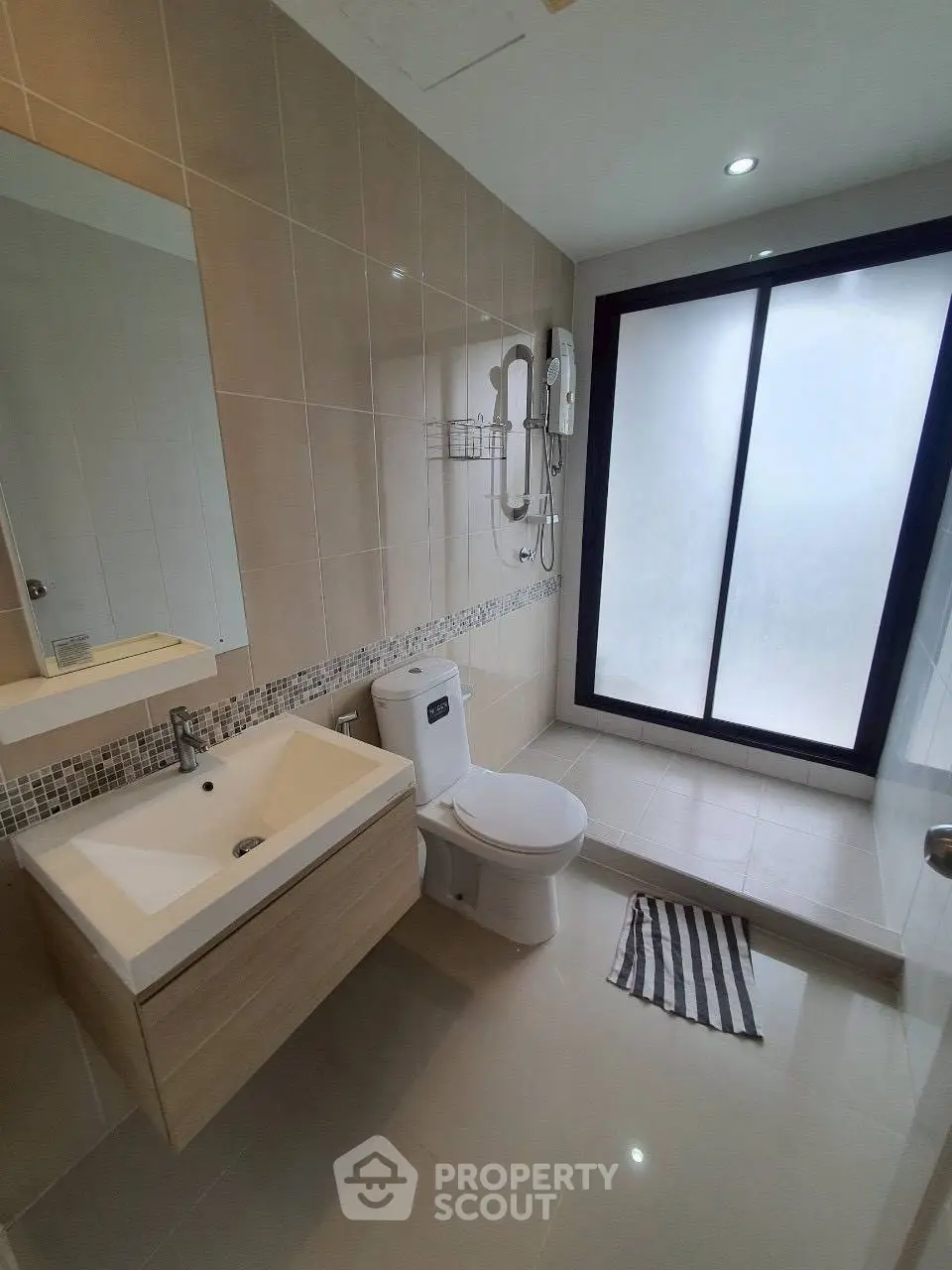 Modern bathroom with sleek fixtures and large frosted glass shower area.