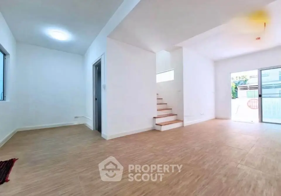 Spacious open-plan living area with modern staircase and natural light