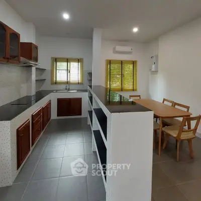 Modern kitchen with sleek countertops and dining area, perfect for family gatherings.