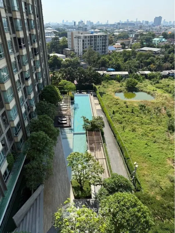 Stunning high-rise building with pool and lush greenery offering panoramic city views.