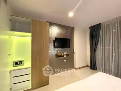 Modern bedroom with built-in storage and wall-mounted TV, featuring sleek design and ambient lighting.