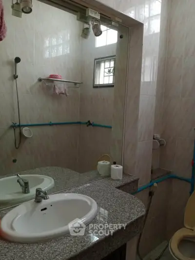 Compact bathroom with granite countertop and wall-mounted mirror
