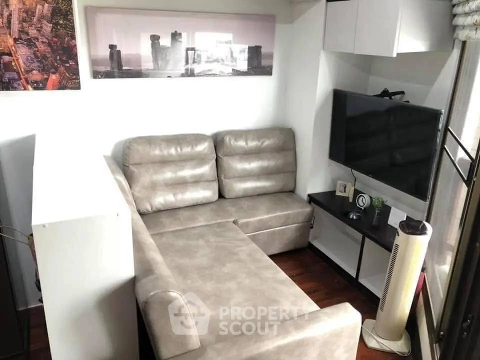 Cozy living room with modern L-shaped sofa and wall-mounted TV, perfect for relaxation.