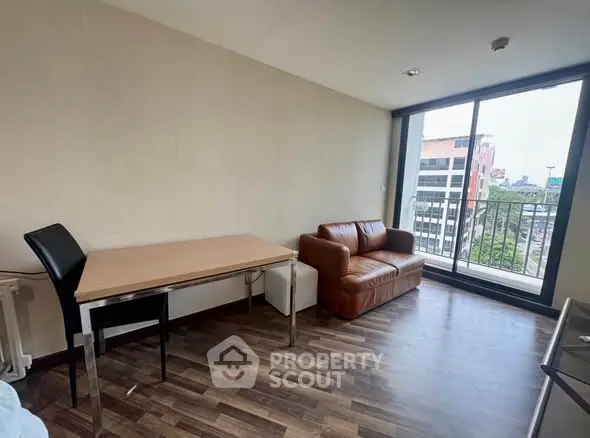 Modern living room with city view, featuring a cozy leather sofa and sleek dining table.