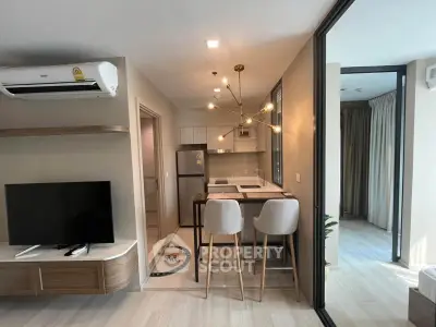 Modern open-plan living room and kitchen with stylish lighting and sleek furniture