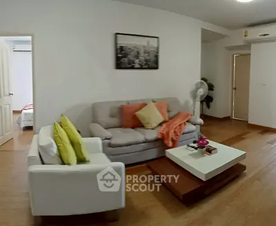 Spacious living room with modern decor and cozy seating in a stylish apartment.