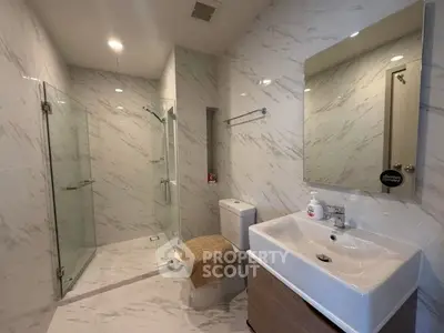 Luxurious modern bathroom with marble walls and glass shower enclosure