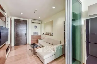 Modern living room with sleek furniture and glass sliding door in a stylish apartment.