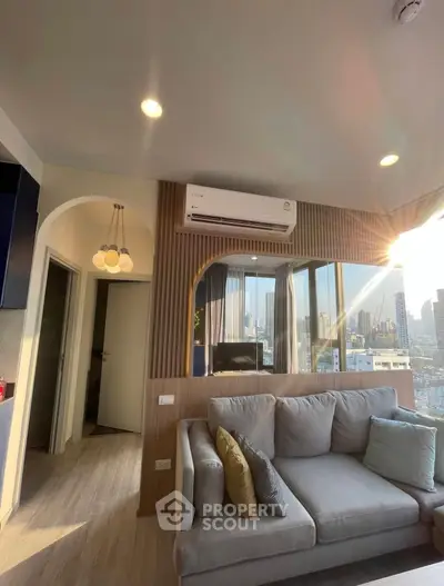 Modern living room with city view, stylish decor, and natural light