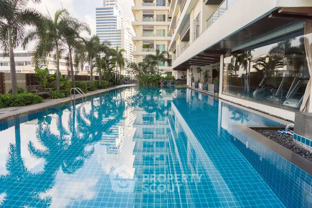 Luxurious condominium pool with city views and lush greenery