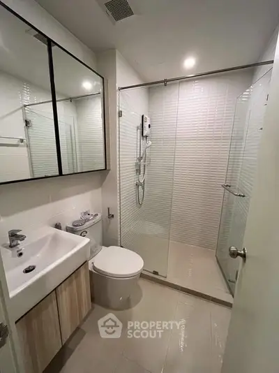 Modern bathroom with glass shower and sleek vanity in contemporary apartment