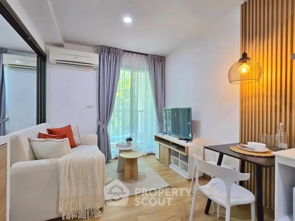 Modern living room with cozy decor and natural light, featuring a small dining area and stylish furnishings.