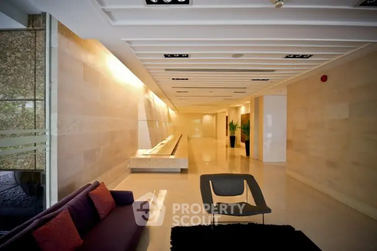 Luxurious modern building lobby with sleek design and elegant seating area.