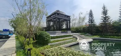 Luxurious garden with elegant gazebo and serene pond in upscale real estate setting.