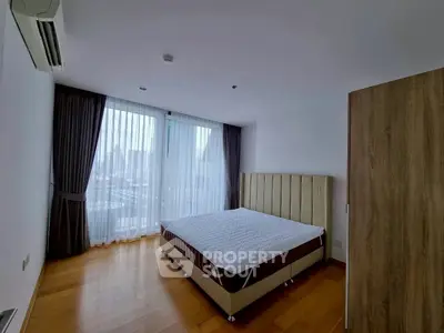Spacious bedroom with large window and city view, featuring modern design and ample natural light.