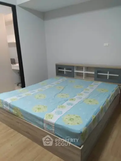 Spacious bedroom with modern bed and wooden flooring in a stylish apartment.