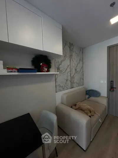 Modern living room with sleek furniture and marble accent wall, perfect for urban living.