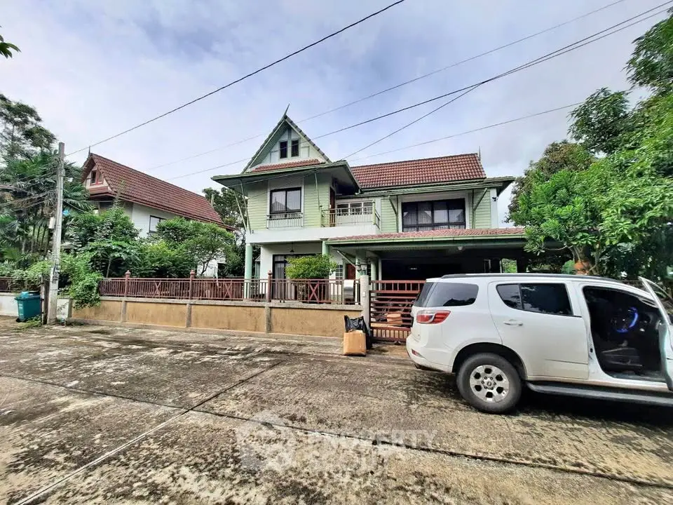 Charming two-story house with lush greenery and spacious driveway in a serene neighborhood.