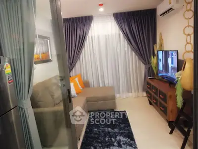 Cozy living room with modern decor and large TV, perfect for relaxation.