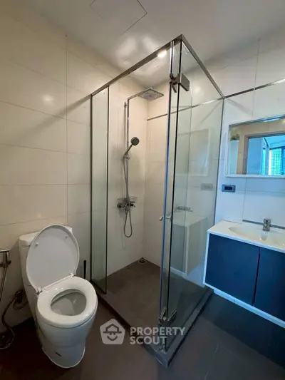 Modern bathroom with glass shower enclosure and sleek fixtures