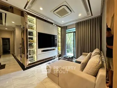 Luxurious living room with modern decor, large TV, and elegant lighting.
