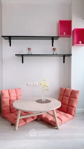 Cozy minimalist living area with pink cushions and modern shelving