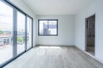 Spacious modern room with large windows and wooden flooring