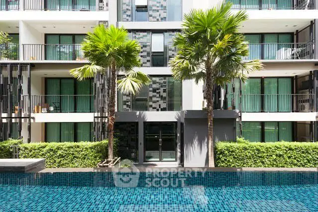 Modern apartment building with pool and lush greenery