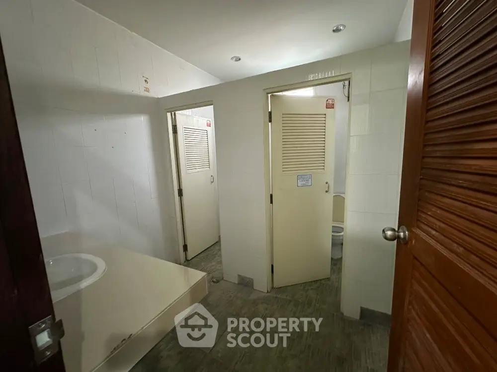 Spacious bathroom with multiple stalls and modern fixtures