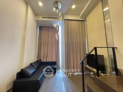 Modern living room with high ceilings and elegant lighting in a stylish apartment.
