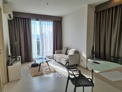 Modern living room with large window and stylish furniture in a bright apartment.