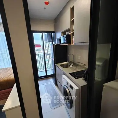 Compact modern kitchen with washing machine and balcony view