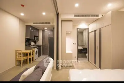 Modern studio apartment with open layout, featuring a compact kitchen and cozy living area.