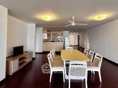 Spacious open-plan living and dining area with modern furnishings and wooden flooring.