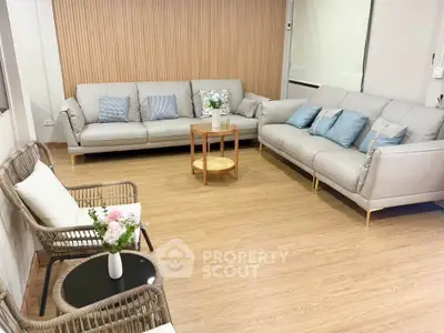Elegant living room with modern sofas and wooden flooring, perfect for relaxation and entertaining.