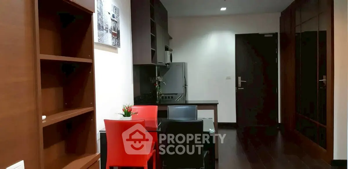 Modern kitchen with sleek cabinetry and dining area in stylish apartment.
