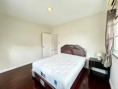 Spacious bedroom with hardwood floors and natural light