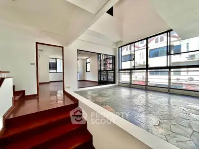 Spacious modern living area with large windows and unique flooring