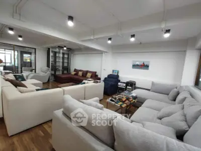 Spacious modern living room with stylish sofas and ample natural light, perfect for relaxation and entertainment.