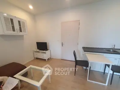 Cozy living room with modern furniture and compact kitchen area.