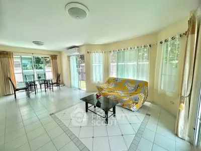Spacious living room with large windows and modern furnishings in a bright, airy home.