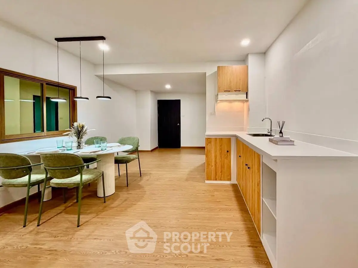 Modern open-plan kitchen and dining area with stylish wooden flooring and contemporary furniture.