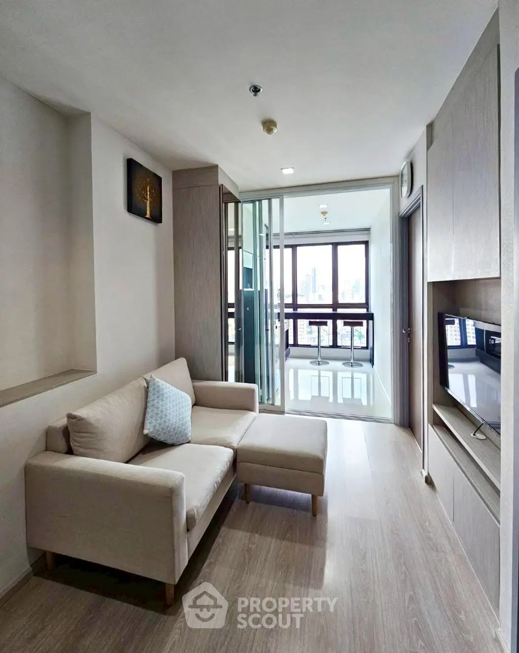 Modern living room with cozy sofa and city view through large windows