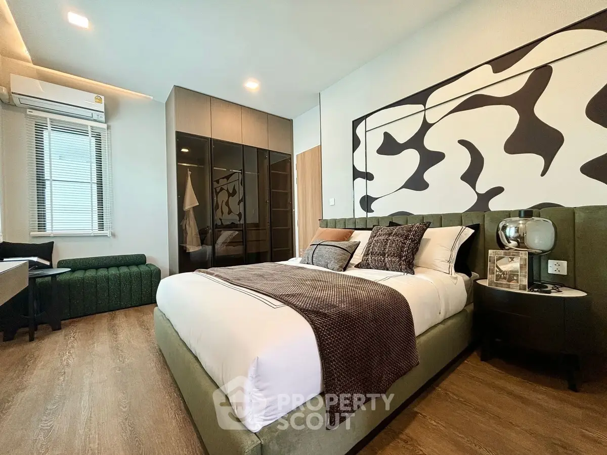 Luxurious bedroom with modern decor and stylish furnishings, featuring a large bed and elegant artwork.