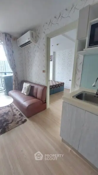 Modern apartment interior with cozy living room and bedroom view, featuring stylish decor and natural light.
