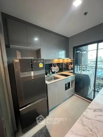 Modern kitchen with sleek cabinets and large fridge in a stylish apartment