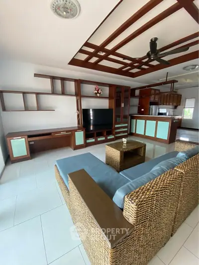 Spacious living room with modern wicker furniture and built-in entertainment center