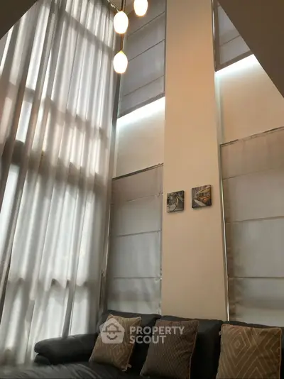 Spacious living room with high ceilings and elegant curtains
