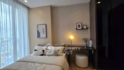 Modern bedroom with stylish decor and large window offering natural light