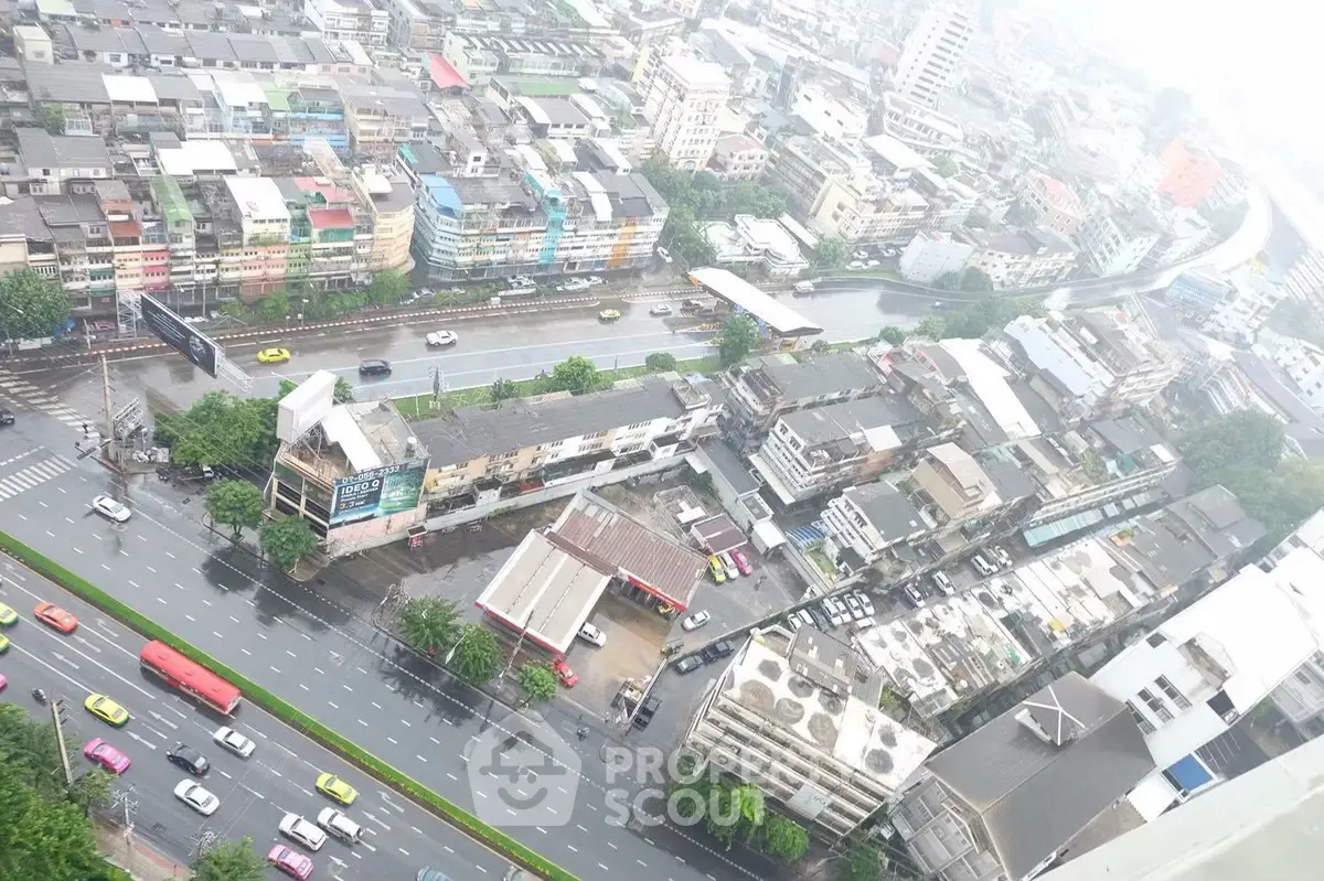 Aerial view of urban cityscape with roads and buildings on a rainy day.